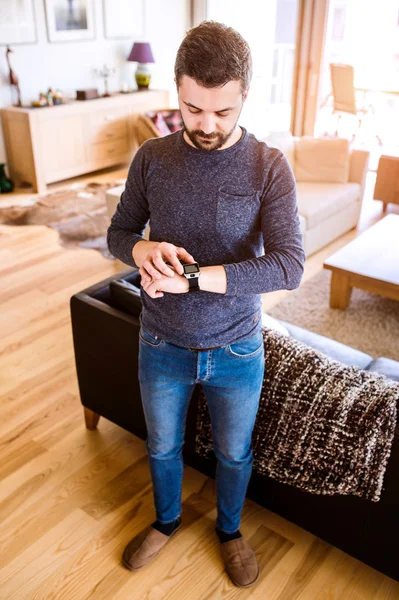 Man som arbetar hemifrån med hjälp av smart Watch-klocka, vardagsrum — Stockfoto