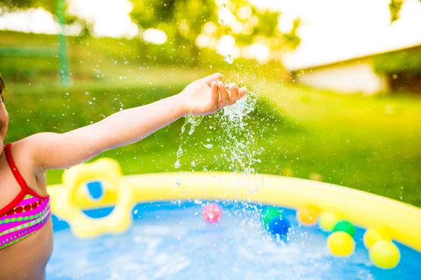 Chica irreconocible divirtiéndose en la piscina del jardín . — Foto de Stock