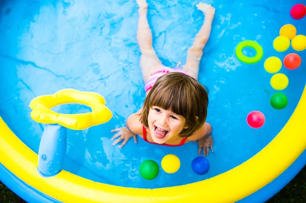 Malá dívka se baví v zahradním bazénu. — Stock fotografie