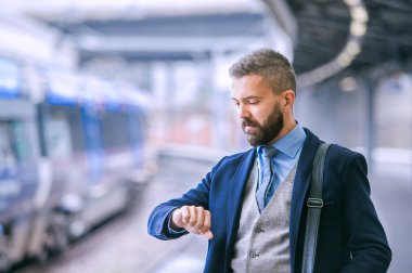 hipster businessman waiting at train station clipart