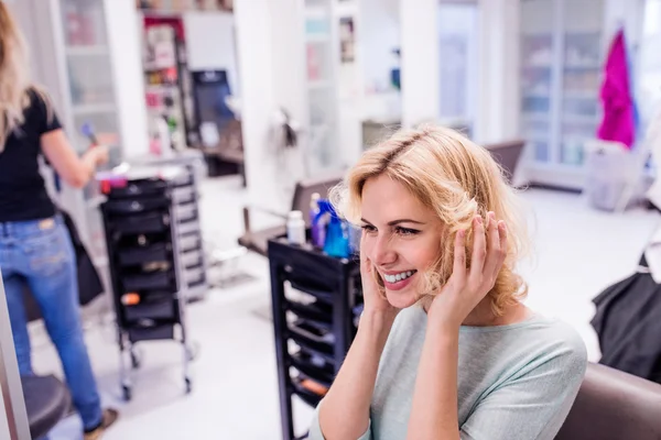 Young blond woman at hairdresser salon — Stock Photo, Image