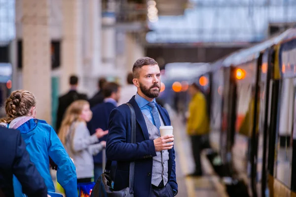 Empresário com café na estação de trem — Fotografia de Stock