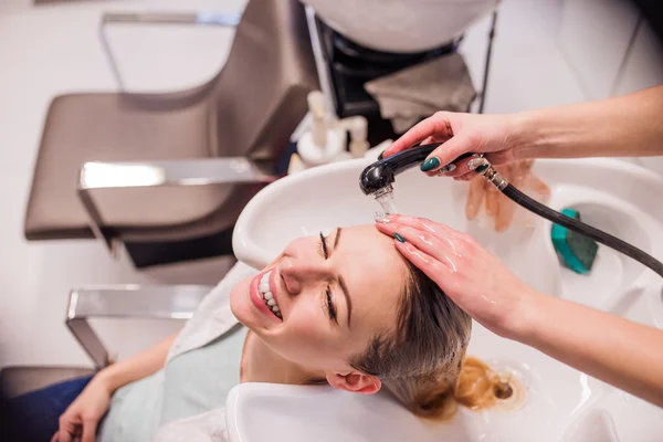 Hairdresser washing hair to her client — Stock Photo, Image