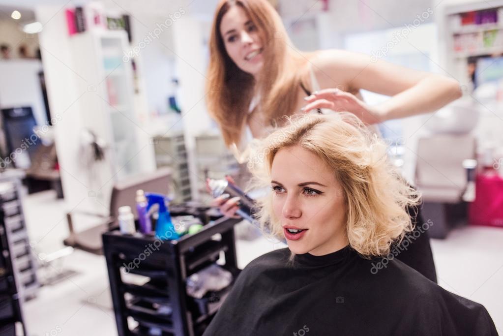 Hairdresser making haircut to woman