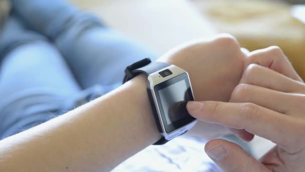 Man som ligger på soffan hemma med hjälp av smart Watch-klocka — Stockvideo