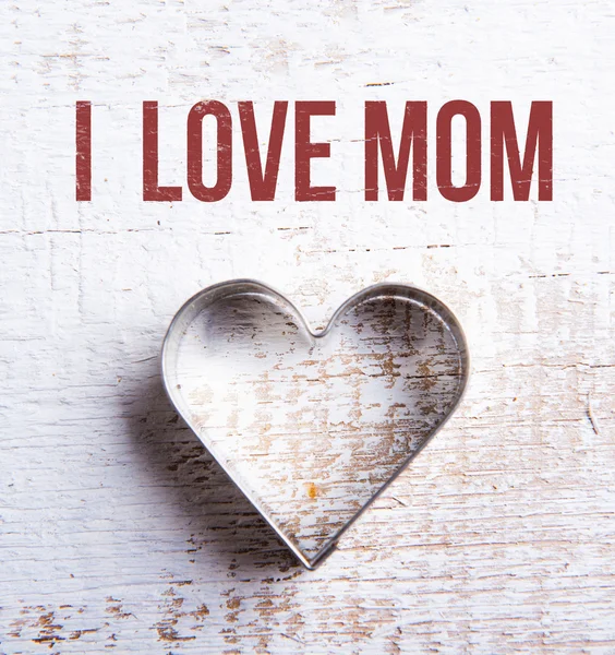 Mothers day composition. Heart shape cookie cutter. Wooden backg — Stock Photo, Image