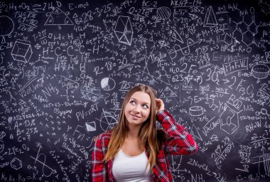 Öğrenci matematiksel semboller ile büyük bir tahta karşı