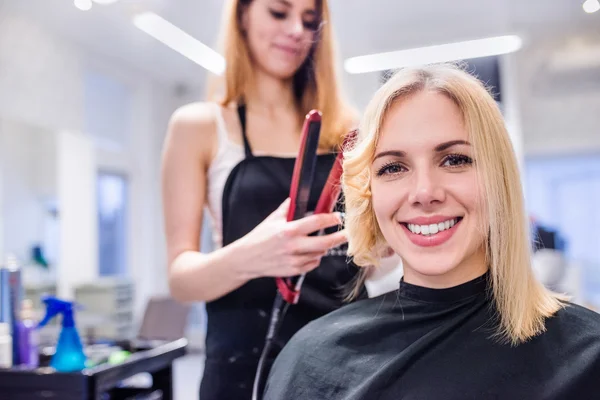 Невпізнаваний перукар створює зачіску для її красивої — стокове фото