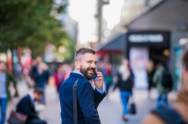 Hipster Yöneticisi ile sokakta yürürken akıllı telefon