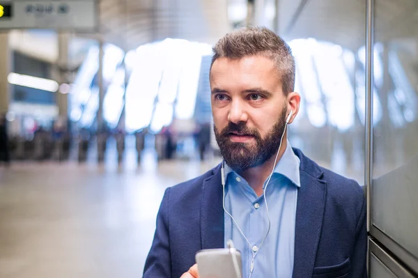 Close up of hipster businessman with smartphone, subway station — Stock Photo, Image