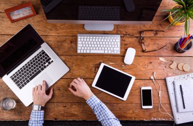 Ofis masasında çalışan, akıllı saat takan iş adamı