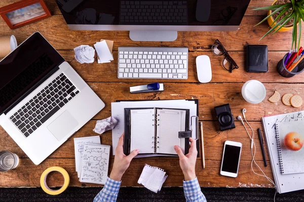 İşadamı kişisel organizatör tutuyor. Gadget'lar ve ofis suppl