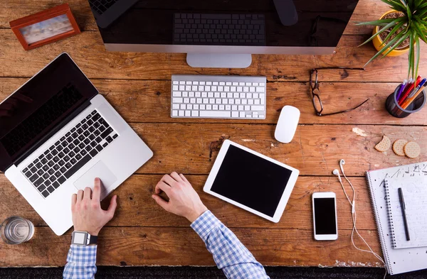 Ofis masasında çalışan, akıllı saat takan iş adamı