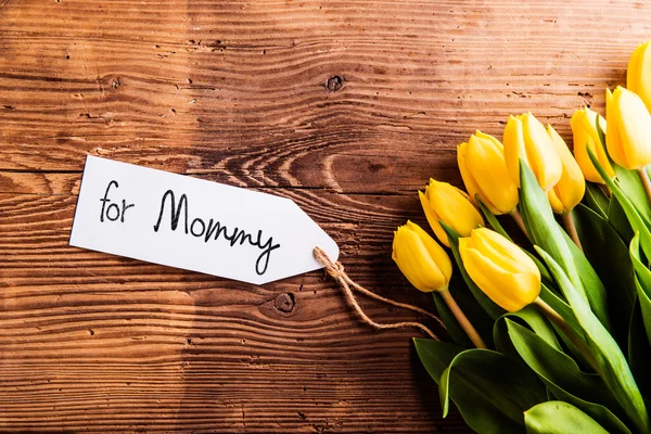 Kompozycja dzień matki, żółte tulipany i Mama tag — Zdjęcie stockowe