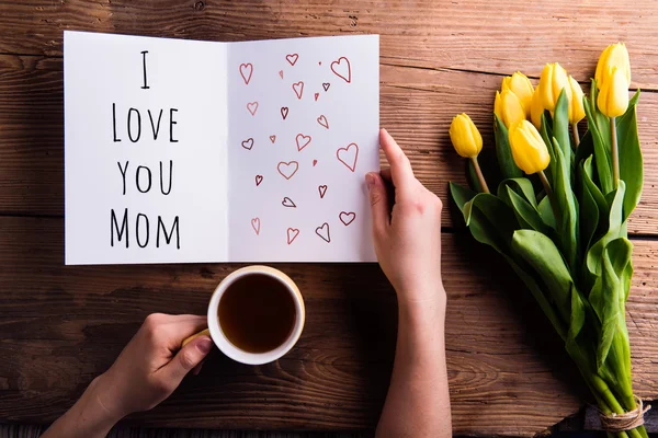 Vrouw met moeders dag groet en koffie. Gele tulpen. — Stockfoto