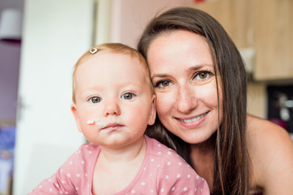 Close up of mother holding her cute baby daughter
