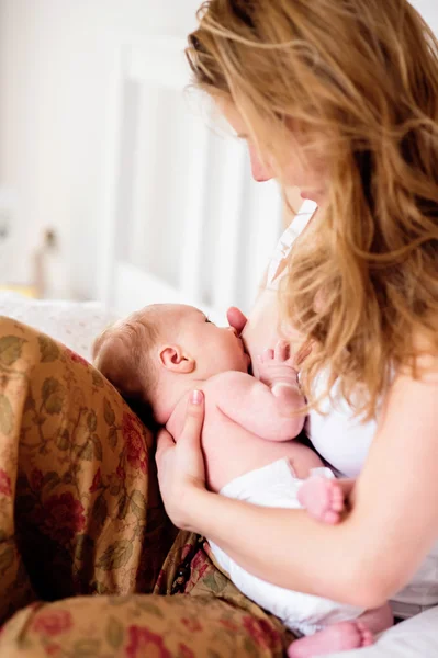 Genç anne emzirme onun yeni doğan bebek evlat, eve yatak odası — Stok fotoğraf