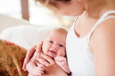 Genç anne tutarak onun yeni doğan bebek evlat, eve yatak odası