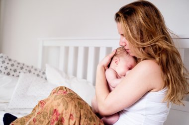 Genç anne tutarak onun yeni doğan bebek evlat, eve yatak odası