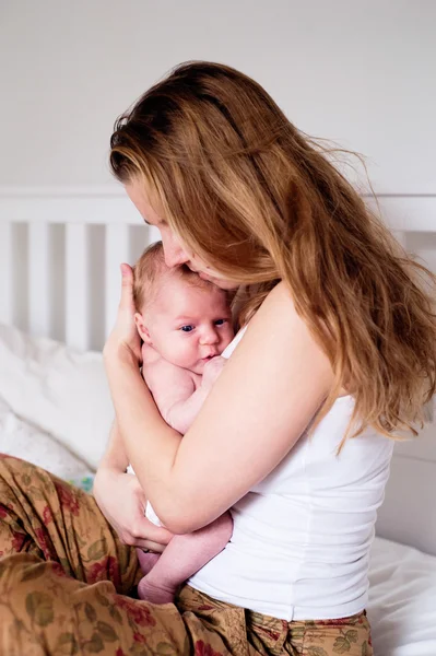 Młoda matka trzyma jej noworodka syna, Strona główna sypialnia — Zdjęcie stockowe