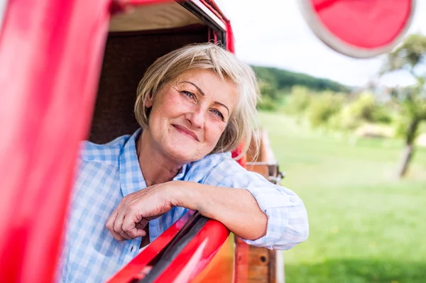 Senior woman inside vintage truck — Stock Photo, Image