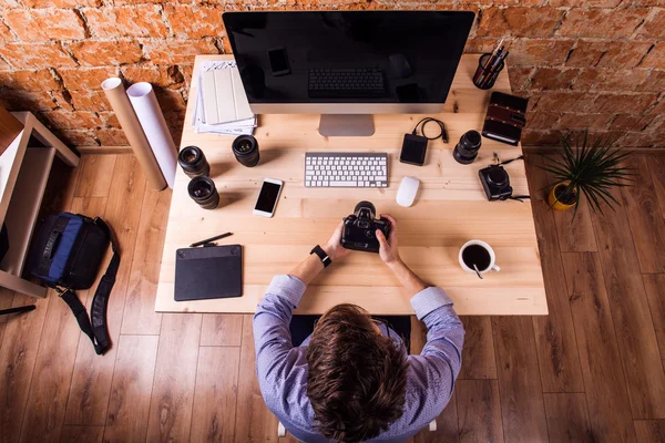 Fotógrafo com gadgets de escritório e lente — Fotografia de Stock