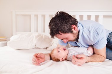 Babasıyla yatakta erkek bebek