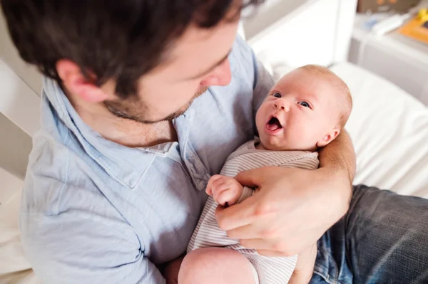 Jonge vader houdt van zijn pasgeboren zoon — Stockfoto