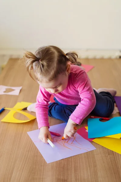 Little girl drawing on colorful papers — Stock Photo, Image