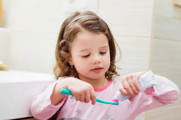 Gadis kecil dengan pasta gigi dan sikat gigi — Stok Foto
