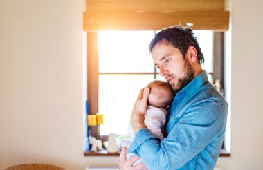 Yeni doğan bebek oğlu onun kolundan tutarak genç Baba