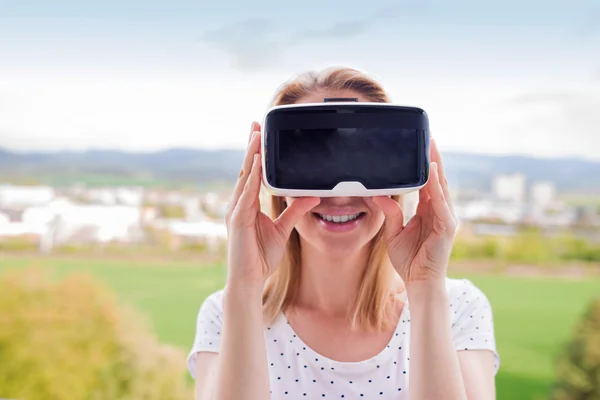 Mujer con gafas de realidad virtual de pie en una cocina —  Fotos de Stock