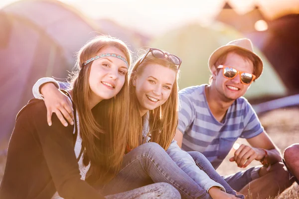 Teenagers sitting in front of tents — Stock Photo, Image