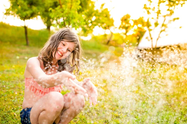 Ragazza in bikini seduta a sprinkler — Foto Stock