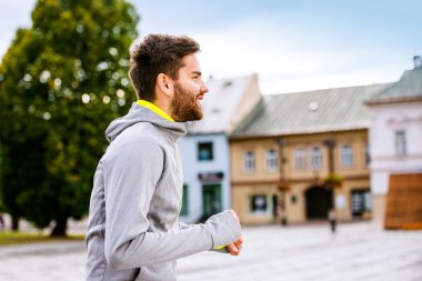 Kasabada koşan genç hipster adam 
