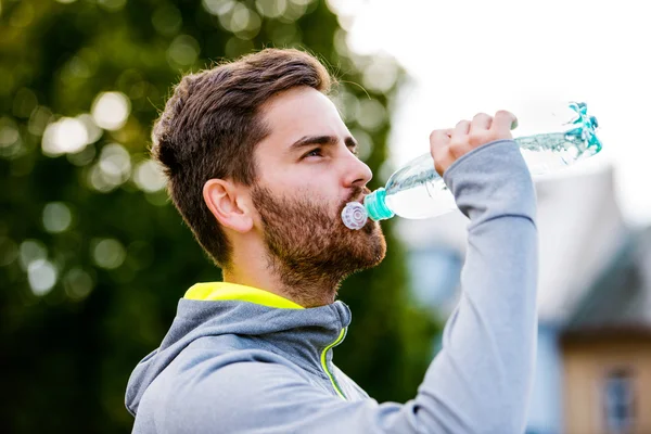 Runner in town with water bottle — Stock Photo, Image
