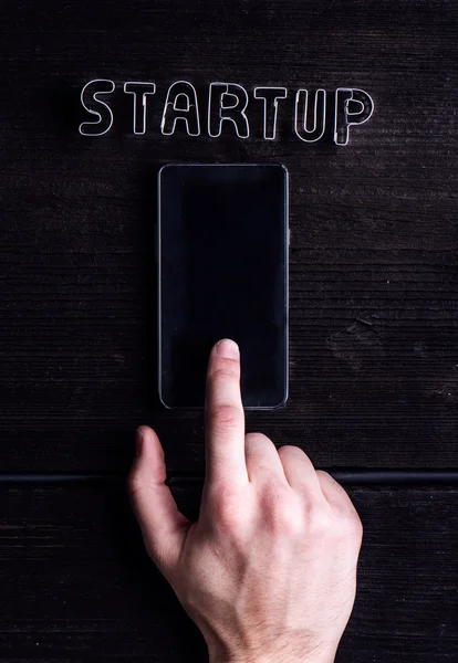 Hand of man writing on smartphone, start up sign — Stock Photo, Image