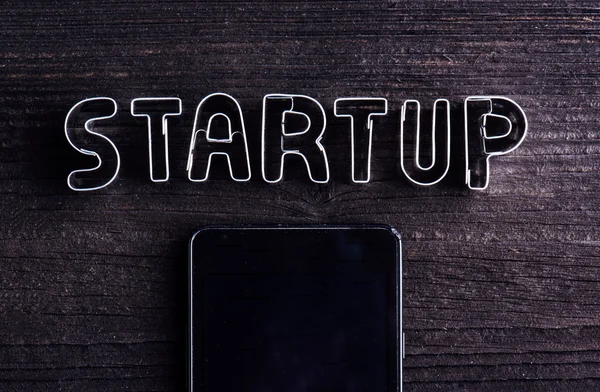 Smartphone and start up sign made of cookie cutters — Stock Photo, Image