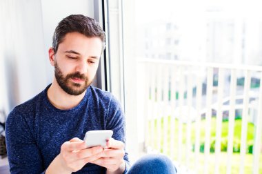 Çalışma home, holding smartphone, texti hipster işadamı