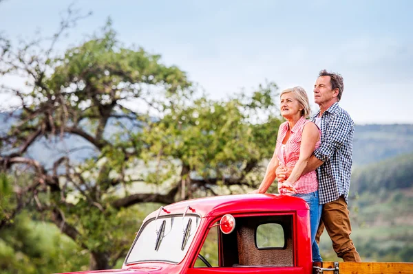 Senioren-Ehepaar steht in rotem Pickup hinten — Stockfoto