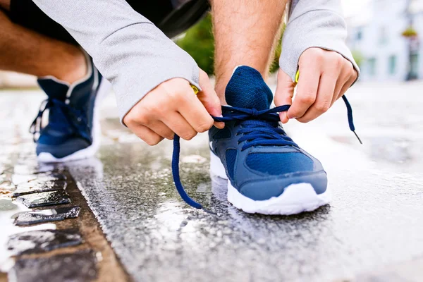 Человек бегун завязывающий шнурки — стоковое фото