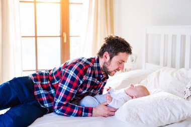 yatakta erkek bebek ile baba