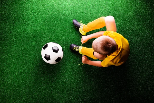 Pequeno jogador de futebol na grama verde — Fotografia de Stock