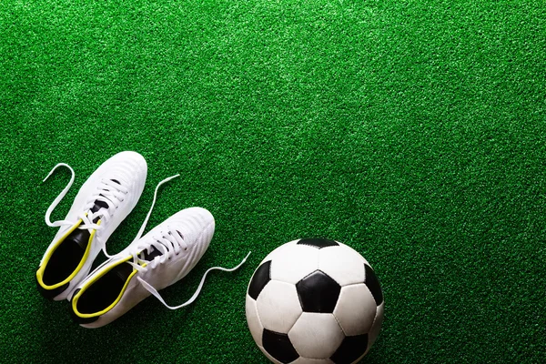 Soccer ball and boots on grass — Stock Photo, Image