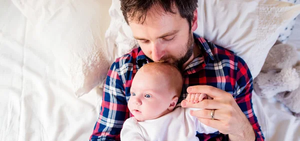 Vader met baby jongen op bed — Stockfoto