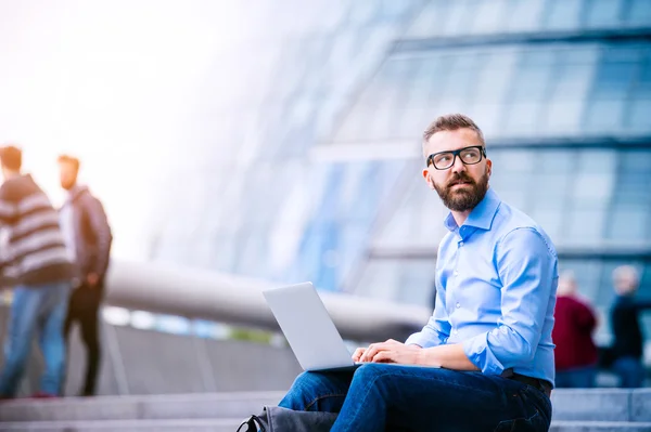 Manager with laptop sitting on stairs — Stock Photo, Image