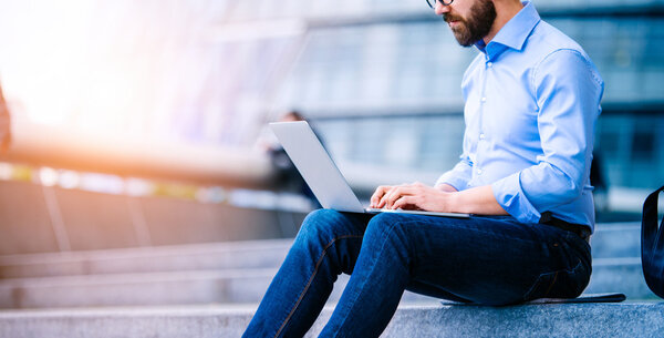 Manager with laptop sitting on stairs 