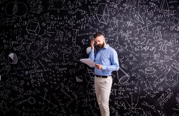 Profesor con cuaderno contra pizarra grande —  Fotos de Stock