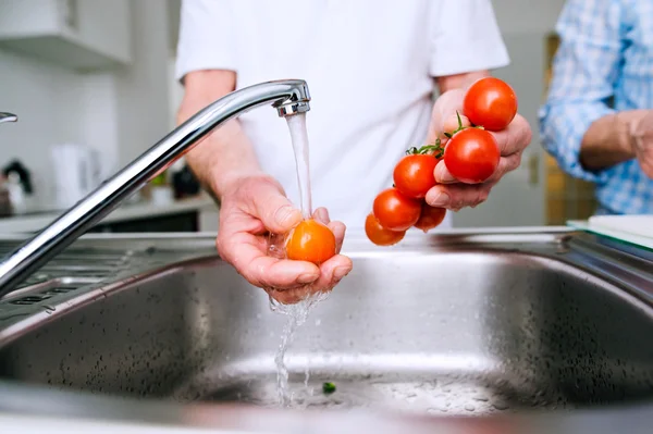 Руки невпізнаваного старшого чоловіка миють помідори. Підготовка b — стокове фото