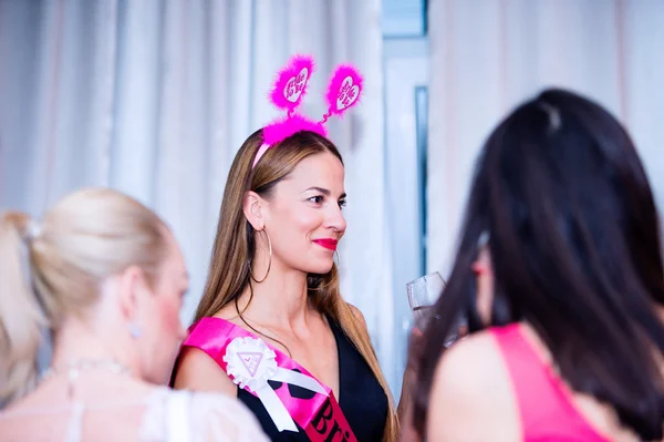 Cheerful bride and bridesmaids celebrating hen party with drinks — Stock Photo, Image